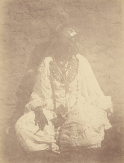 [Portret van een Noord-Afrikaanse vrouw zittend tegen een muur]. door Théodule Devéria