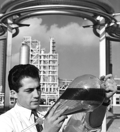 Een laboratoriummedewerker houdt een scheitrechter met olie vast, Dunkirk raffinaderij, Frankrijk, 1950s door Unbekannt