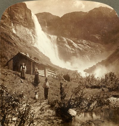 Eenvoudig bergthuis aan de voet van kliffen waar de Skiaeggedals-waterval 525 ft. valt, Noorwegen, ca. 1905 door Unbekannt