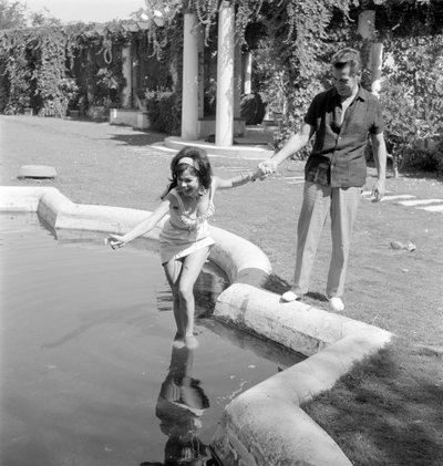 De actrice Laya Raki met de acteur Ron Randell op het Lido van Venetië - 1961 door Unbekannt