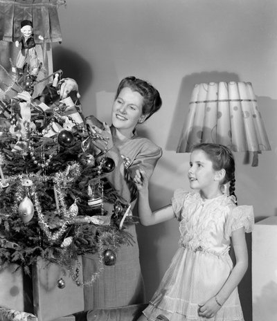 Vrouw en meisje versieren een kerstboom, ca. 1948 door Unbekannt