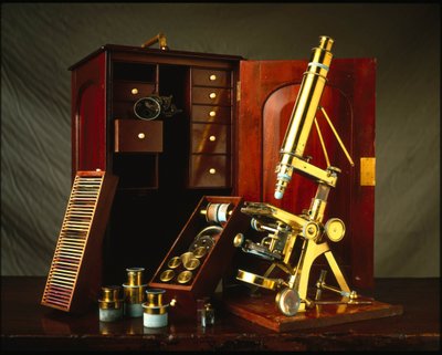 Powell en Lealand messing microscoop met drie poten, uitgerust met een houten doos met diverse accessoires. door Unbekannt
