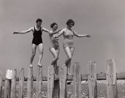 Twee vrouwen en een man wandelen langs een golfbreker, ca. 1930s door Unbekannt