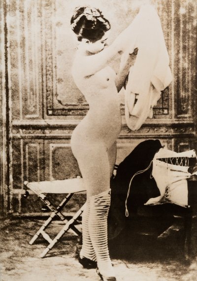 Volledig naakt portret van een jonge vrouw die zich aankleedt. door Unknown photographer
