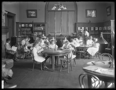 Kinderen lezen in de leeszaal van een niet-geïdentificeerde vestiging van de Queens Borough Public Library, ca. 1910 door William Davis Hassler