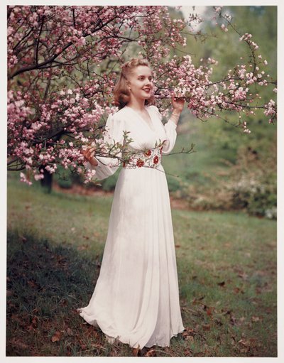 Vrouw die een jurk modelleert bij bloesem, ca. 1940s door Frederick (attr. to) Barnard