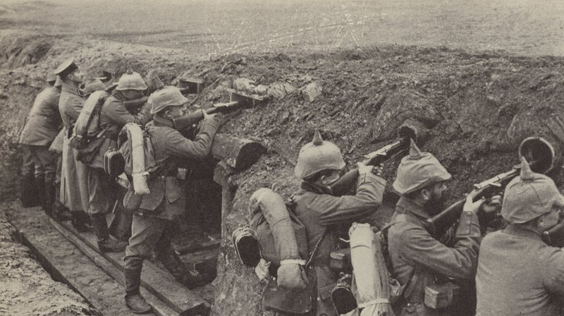 Duitse soldaten in de loopgraven in Vlaanderen die door schietgaten gemaakt van kleine houten kisten en rioolbuizen schieten door Photographer German