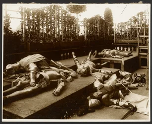 [Zes mannelijke modellen als oude krijgers gekleed in harnas die doen alsof ze dood zijn].