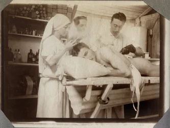 Eerste Wereldoorlog 1914-1918: artsen en verpleegster behandelen de wonden van een soldaat in de verbandkamer, kamp van Couville in het Kanaal, Laag-Normandië, Frankrijk. Anonieme foto juli 1917. Privécollectie, Stella.