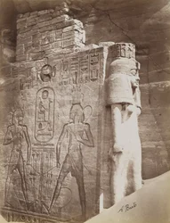 Koningin bij de Tempel van Abu Simbel, detail van troon en koningin onder het zittende Standbeeld van Ramses II aan de noordzijde van de ingang van de Zuidelijke Tempel