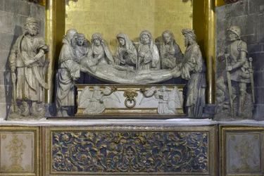 Het graf: het lijkwade van Christus wordt vastgehouden door Nicomede en Jozef van Arimathea die het hoofd van Jezus vasthoudt, daarachter ondersteunt Sint Jan de Maagd Maria, gevolgd door drie vrouwen, de eerste draagt de kroon van doornen en de laatste is
