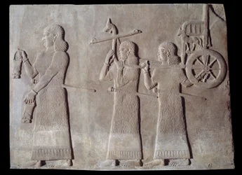 Hof van het paleis van de koning van Assyrië Sargon II, dienaren dragen de situles en de strijdwagen van de koning