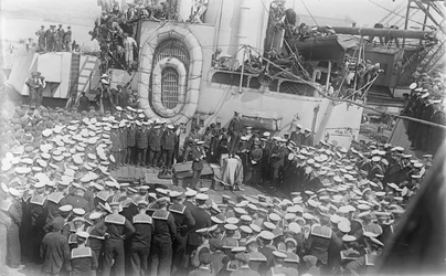 Zeelieden verzamelen zich rond de Australische premier The Hon William Morris (Billy) Hughes terwijl hij hen toespreekt op het dek van HMAS Australia in de scheepswerf in Devon, Engeland, 21 mei 1916