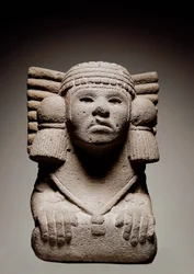 Azteekse beschaving: Stenen beeld dat de Azteekse watergodheid Chalchiuhtlicue, ook Chalchiuhtlic genoemd, voorstelt. Zij is afgebeeld als een vrouw met gebogen knieën die de traditionele omslagdoek draagt. Rond 500. Uit Mexico. Stenen sculptuur. Madrid.