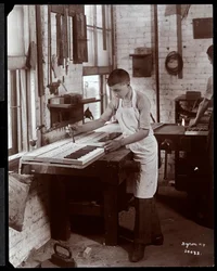 Een jonge man die werkt in de fabriek van Harrington Piano Co., 1907 (zilveren gelatin print)