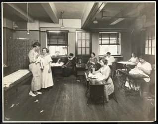 Blinde jonge vrouwen en een leraar die naaien in een klaslokaal bij de New York Association for the Blind, 111 East 59th Street, New York, 1921