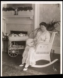 Mevrouw Howard zittend met een boek in een schommelstoel in haar huis op 200, 5th Avenue, New York, 1915-6