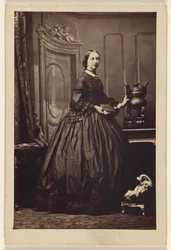 [Ongeïdentificeerde vrouw die een boek vasthoudt, staand].