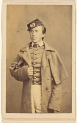 [Ongeïdentificeerde soldaat uit de Burgeroorlog staat, een hand houdt zijn overjas vast].