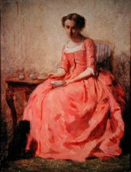 Meisje in een roze jurk aan een tafel