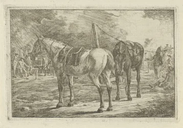 Twee gezadelde paarden bij een legerkamp
