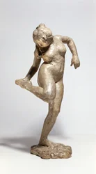 Danseres die naar de zool van haar voet kijkt (gips)