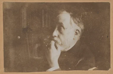 [Zelfportret in bibliotheek (hand aan kin)]