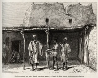 Moslimschoolkinderen zingen een gebed op de binnenplaats van een huis, beoefend in het land van Kong (Niger), de schoolkinderen ontvangen een handvol kaurischelpen, die ze aan hun leraar overhandigen en die overeenkomt met een soort belasting voor openbaar