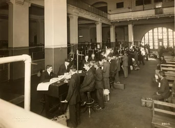 Immigranten worden geregistreerd in de Grote Hal, U.S. Immigratiestation, 1902-10