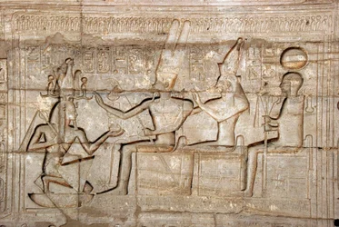 Egyptische oudheden: reliëf dat farao Ramses II voorstelt voor de godheden van de Thebaanse triade, Amon, Mut en Khonsu; Dodentempel gewijd aan farao Ramses II (1279-1213 v.Chr.), site van Ramasseum in Luxor, Egypte