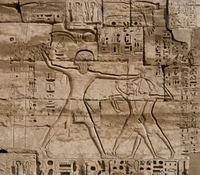 Egyptische antiquiteit: detail van reliëfs die de overwinningen van de Farao over de volkeren van de zee vieren. Begrafenistempel van Ramses III (1187-1156 v.Chr.). Luxor, Medinet Habou, Egypte
