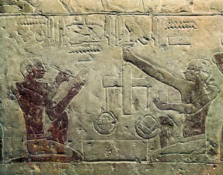 Bas-reliëf dat een koopman en een klant voorstelt: een van de figuren gebruikt een weegschaal terwijl de ander aantekeningen maakt, c.2465-2323 v.Chr.