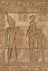 Egyptische oudheid: Romeinse mammisi ter herdenking van de geboorte van Ihy, zoon van Hathor - Detail van reliëfs en hiërogliefen: de godin Isis - Hathor die haar zoon Ihi (Ihy) voedt en achter haar een ander beeld van Ihi met een vinger in zijn mond