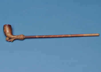 Cup tie pijp met bamboestam en gesneden laars die een bal trapt