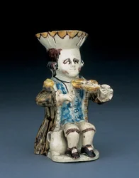 Toby-kan van een violist, zijn hoed met bruin-geel geschulpte rand, zijn bruine haar ingekerfd en met een witte rozet in een staart gebonden, in een bruin gewassen pandjesjas, ca. 1770