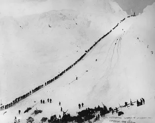Pakkers beklimmen de top van de Chilkoot Pass, uit 