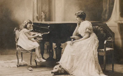 Portret van een vrouw die een jong meisje piano ziet spelen