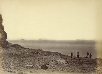 [Zicht op kust met schepen aan horizon en vijf figuren staand op strand].