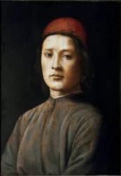 Portret van een jonge man met een rode hoed