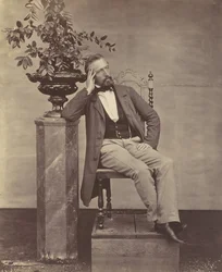 [Mathias Höusermann zittend met elleboog op voetstuk met een vaas bloemen], 1850s-60s