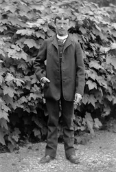 Jonge man met een sigaret, werkzaam als manusje-van-alles, poserend in de tuin van de Abdij van Septfontaines, nabij Bourmont in Haute-Marne, rond 1880. Fotografie. Ducos Collectie.