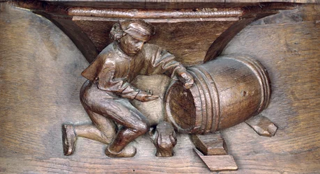 Houtsnijwerk van een man die een kraan op een vat zet, uit een koorbank van de Abdij van St. Lucien in Beauvais (hout)