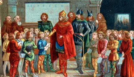 Keizer Karel de Grote bezoekt een school, zijn belangstelling voor onderwijs en leren en zijn bescherming van geleerden hebben ertoe geleid dat hij als beschermheilige van scholen wordt beschouwd.