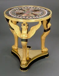 Empire gueridon, bestaande uit een ronde specimen marmeren top met een centraal rozetpatroon omgeven door sterachtige punten, ondersteund door de vleugels van drie sfinx monopodiae, op een driehoekige vergulde basis, ca.1800
