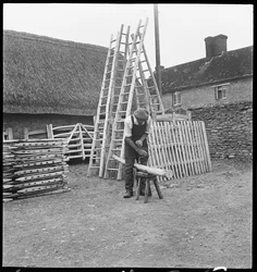 Een man maakt een wilgenladder in het dorp Aston