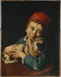 Een jongen, halflang, in een blauw jasje en een rode hoed, met een mopshond op een kussen