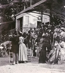 Toeschouwers in de tribunes bepalen de uitkomst van een renbaan in het Cascine Park: de gravin Pucci, gravin Cellesi, de afgevaardigde Filippo Torrigiani, graaf Paszkowski, de vrouw van de Griekse consul, de markiezin Mannelli met dochters, graaf S. Albano