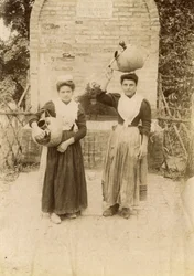 Twee jonge vrouwen in traditionele kleding met terracotta kruiken bij waterput, Marche, Italië, ca 1910