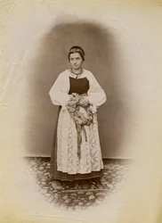 Jonge vrouw in een trouwjurk met een broodring omwikkeld met lint, Parre, Lombardije, Italië, foto door Premiata Fotografia Taramelli, Bergamo