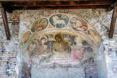 Kruisafneming van Christus tussen de Maagd Maria, St. Johannes, met symbolen van de Evangelisten en Agnus Dei op de boog